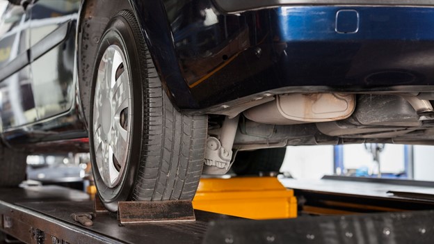 A car being raised on a morn Hydraulic Lifts in a garage.