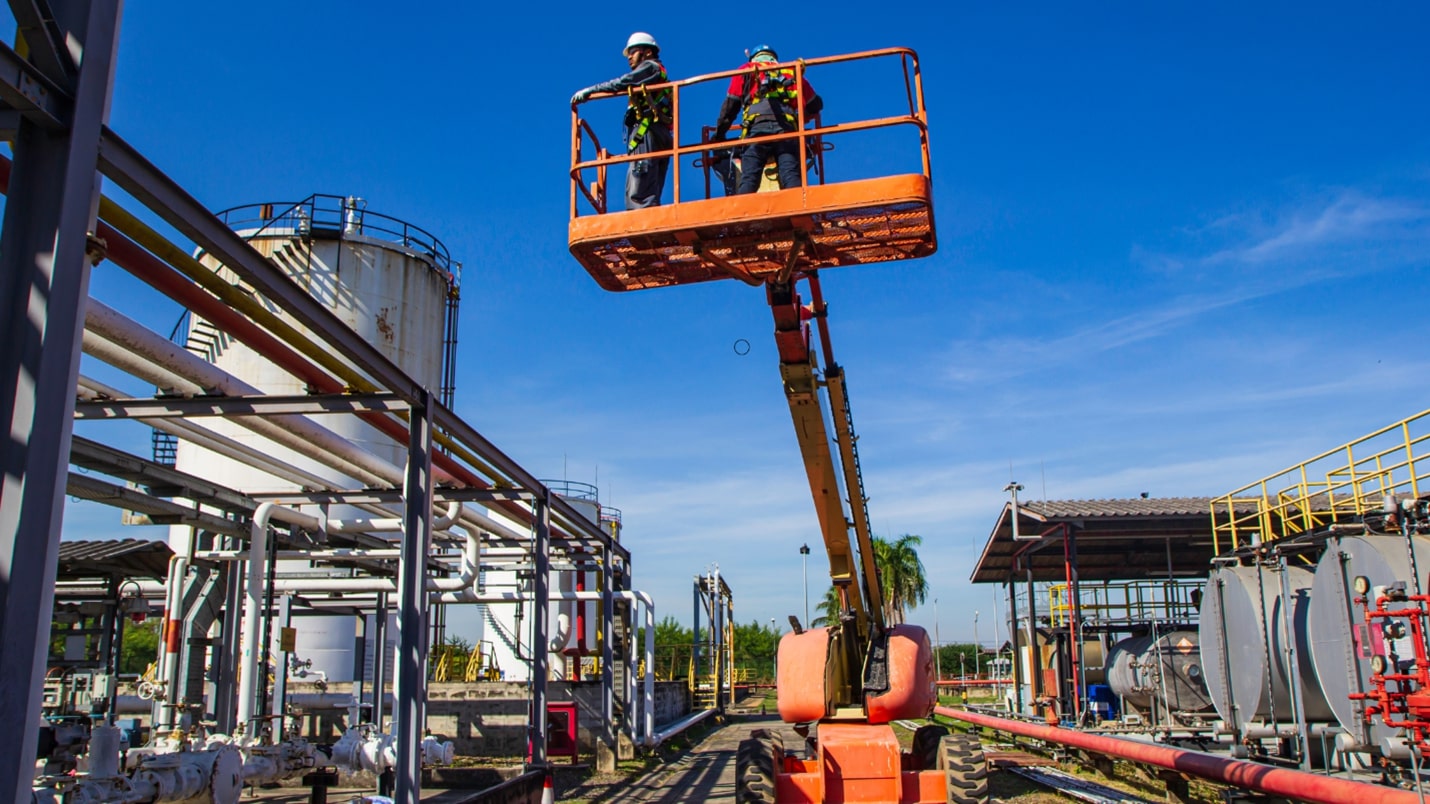 A man standing on a morn lift, reaching out to press a button.