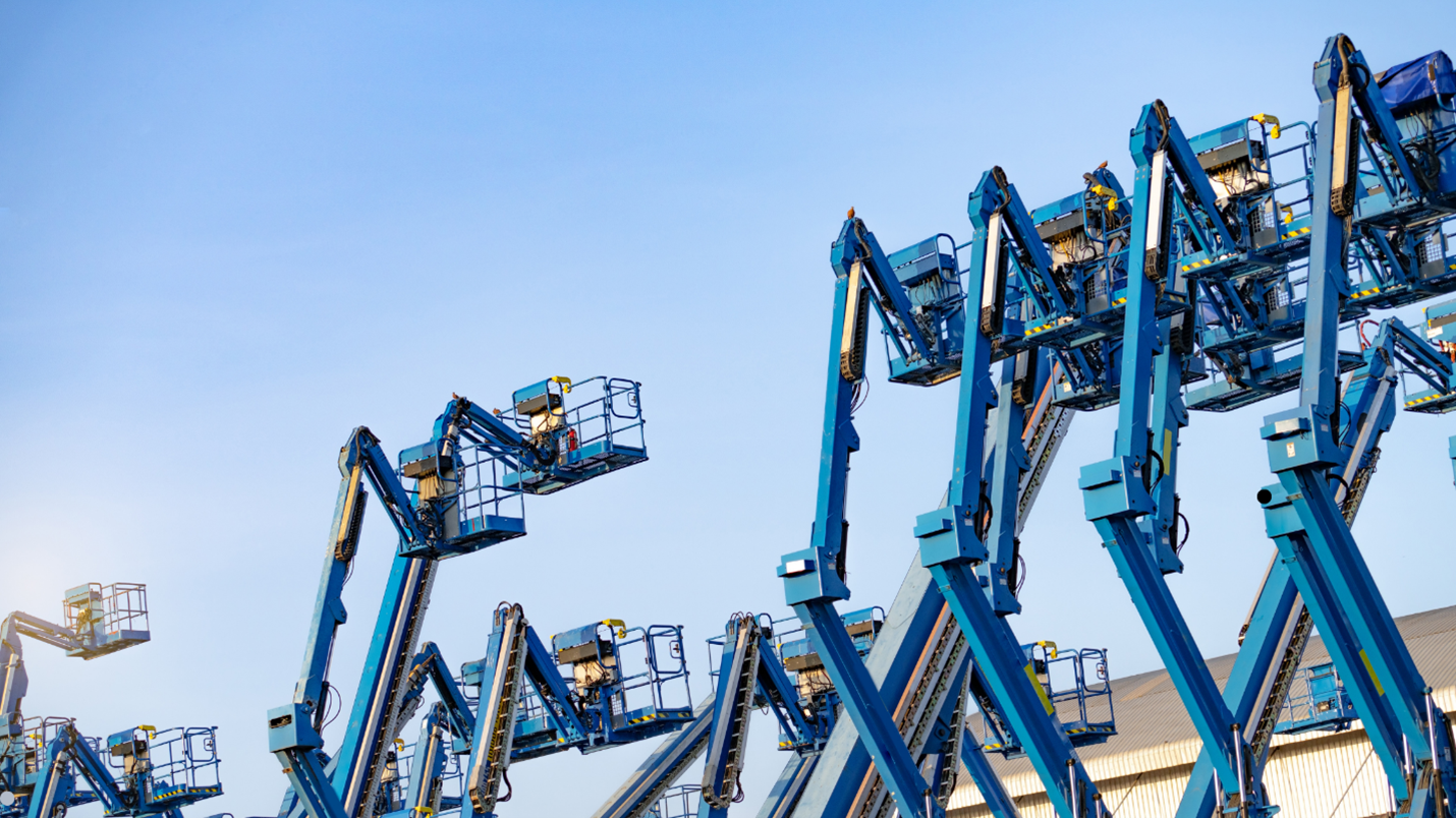 Morn Blue lift trucks lined up in a row at a warehouse.